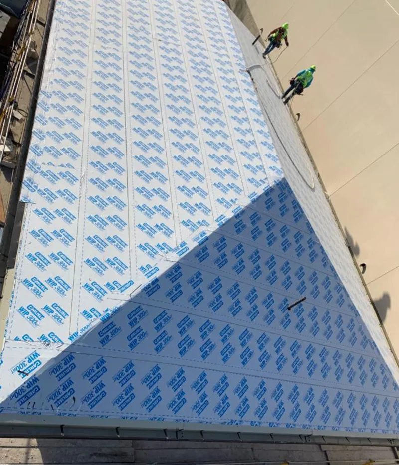 Professional roofers installing underlayment on a metal roof in Washington